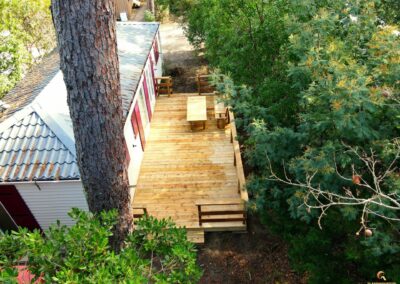 Vue d'une terrasse en bois rénovée avec le configurateur 3D de Glampinovateur, dans un camping des Landes, avec une finition soignée et un aménagement extérieur moderne.