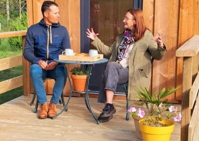 Rencontre entre une cliente et Glampinovateur devant une tiny house bois installée dans un jardin