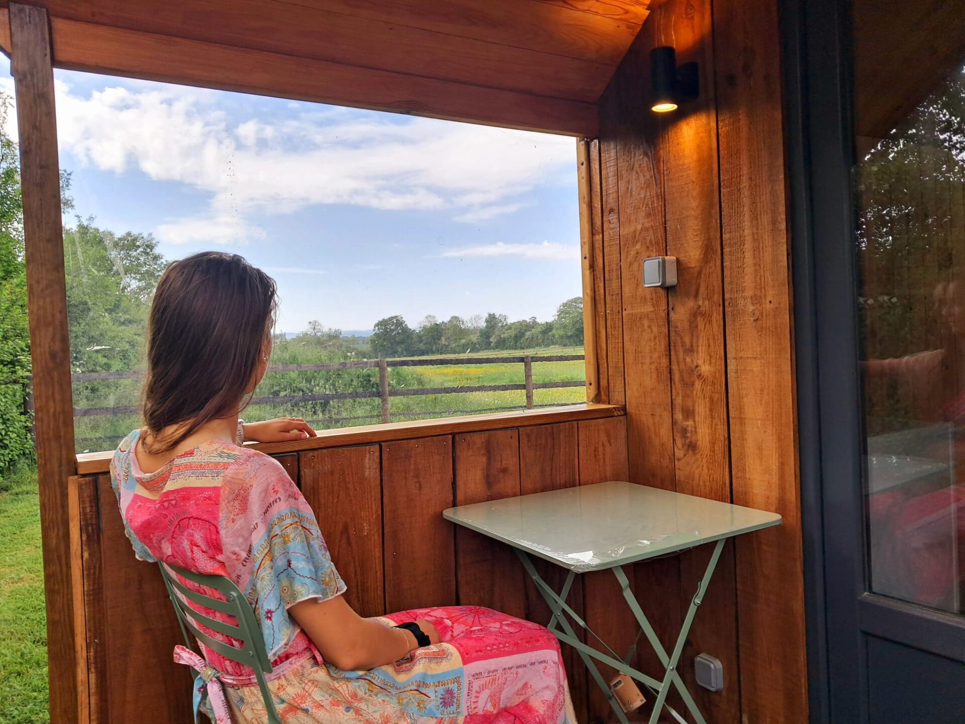 Moment de détente sur la terrasse en bois de l’hébergement insolite Le Rêveur, conçu par Glampinovateur