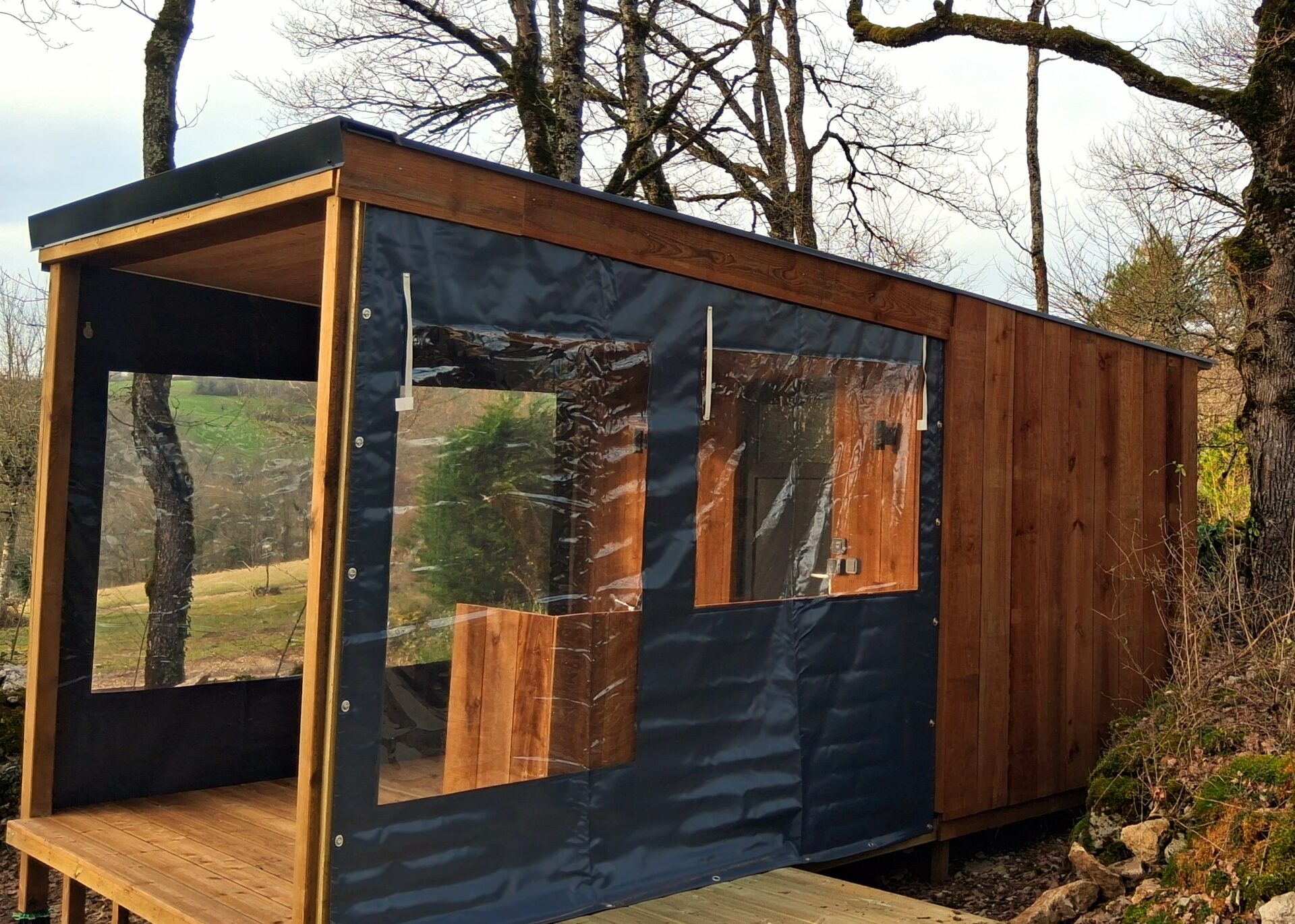 Sanitaire individuel innovant pour camping, avec terrasse et bâches latérales pour protection contre les intempéries – Modèle 'Campeur' de Glampiovateur, expert en hébergements insolites.