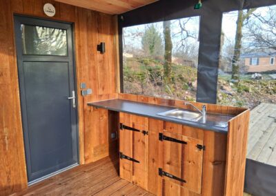 Cuisine de 2m sur terrasse prête à l'emploi avec évier, emplacement pour bouteille de gaz en pin des Landes – Modèle 'Campeur' de Glampinovateur, hébergement insolite pour camping.