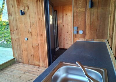 Terrasse couverte de 10m² avec bloc cuisine pour un séjour en camping confortable et pratique, offrant une expérience de détente en plein air.