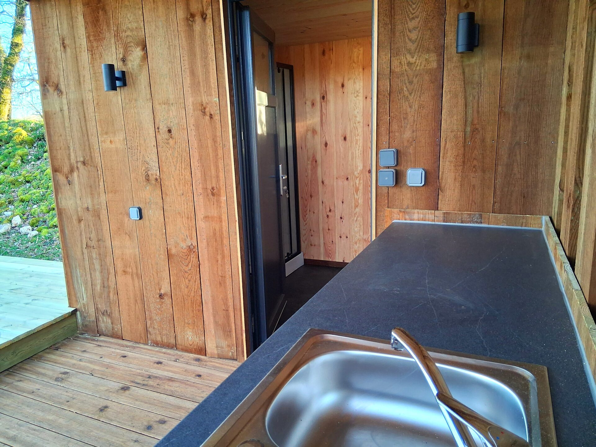Terrasse couverte de 10m² avec bloc cuisine pour un séjour en camping confortable et pratique, offrant une expérience de détente en plein air.