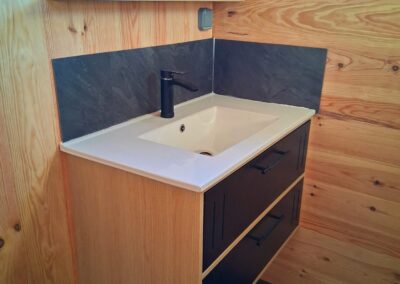 Sanitaire privé avec WC, douche spacieuse et meuble vasque encastré pour un hébergement premium en camping, combinant confort et fonctionnalité