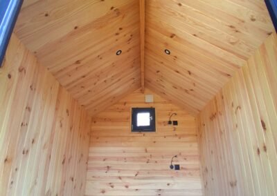 Intérieur du chalet insolite Le Rêveur de Glampinovateur avec lambris bois et ambiance cosy pour hébergement touristique